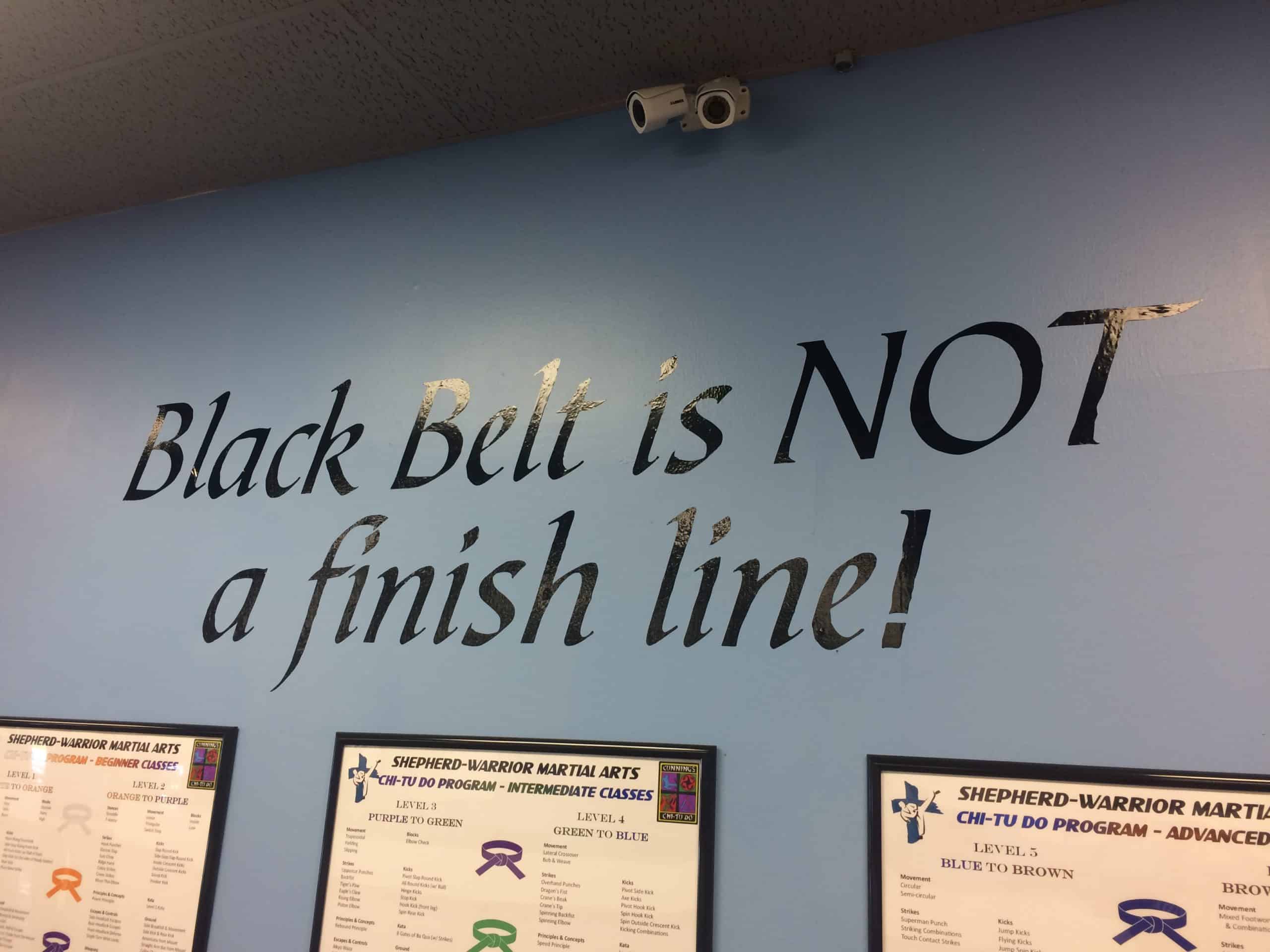 Interior wall with text "Black Belt is NOT a finish line!" at Shepherd-Warrior Martial Arts